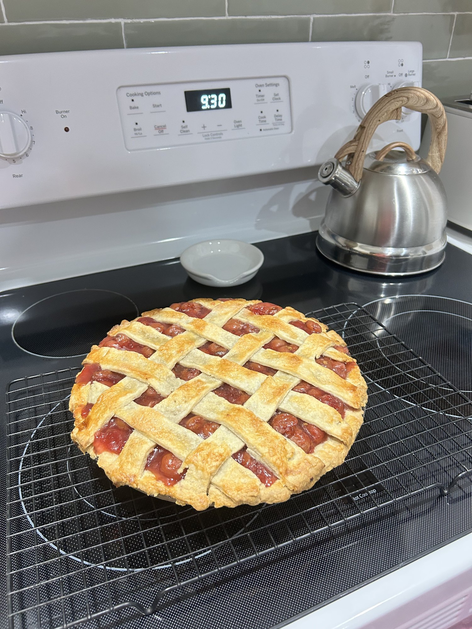 A lattice-crust apple pie cooling on the stove